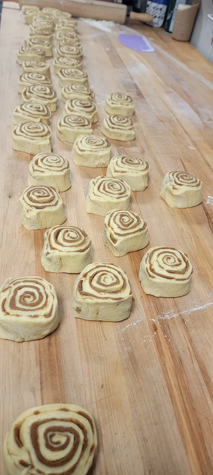 Cinnamon roll dough being rolled in Kaylan's Kitchen